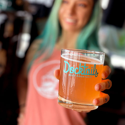 woman holding out beer cocktail