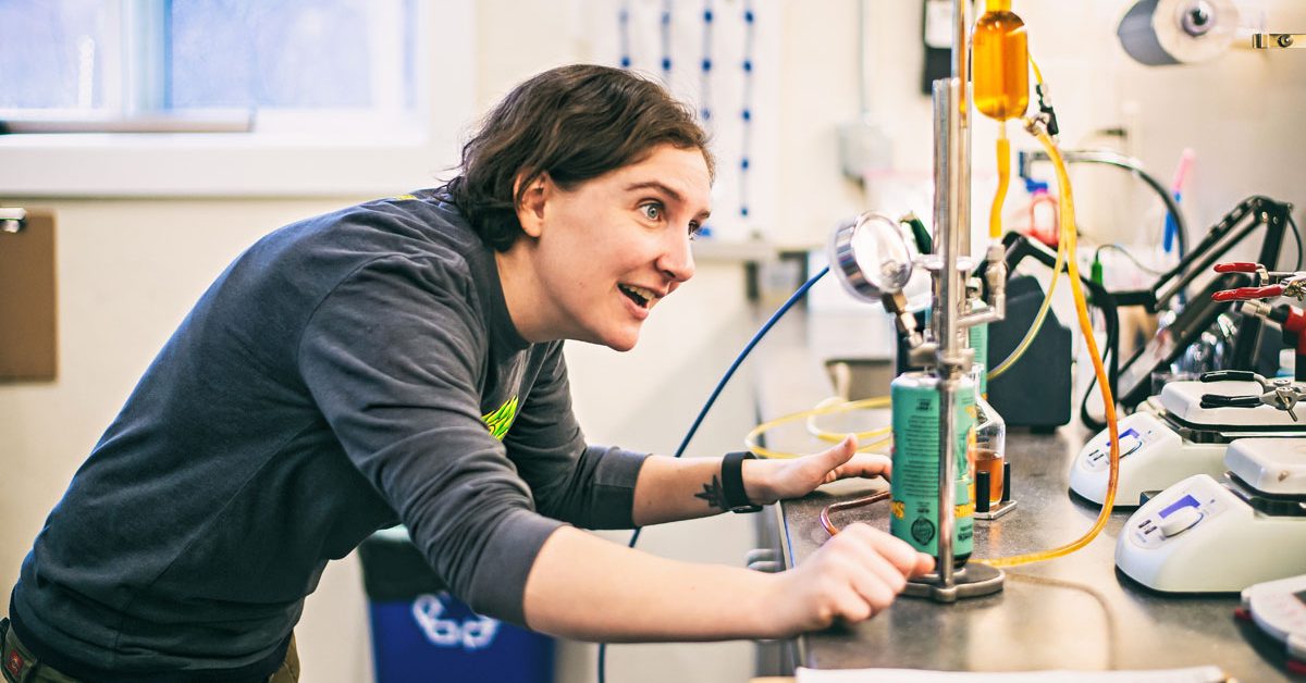 woman working with canned beer in quality lab