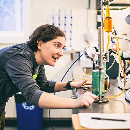 woman working with canned beer in quality lab