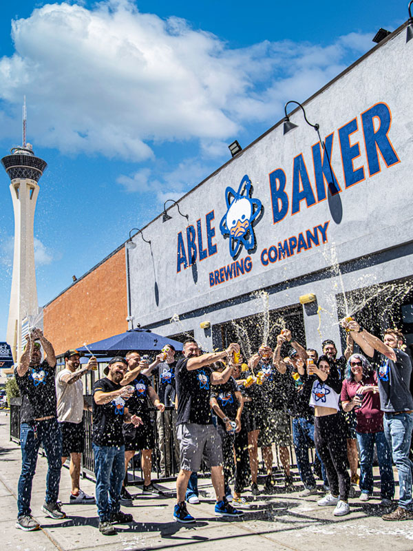 able baker brewing employees celebrating in front of brewery
