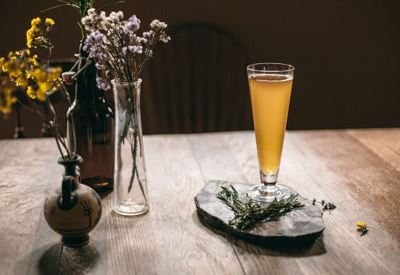 beer and herbs in vases against moody background