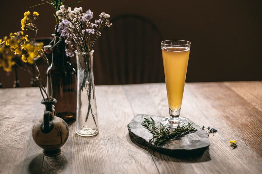 beer and herbs in vases against moody background