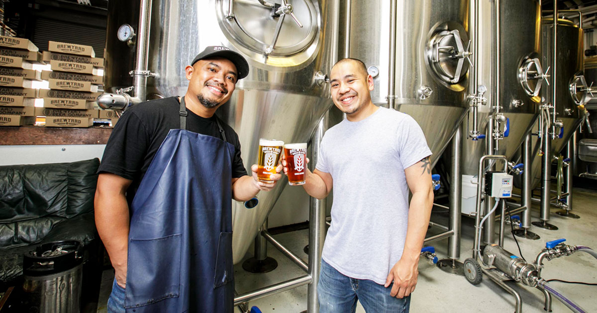 brewers cheersing in beer production area