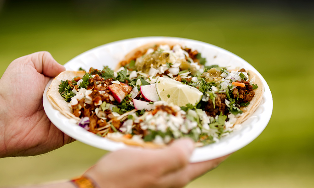 plate of tacos held in hands