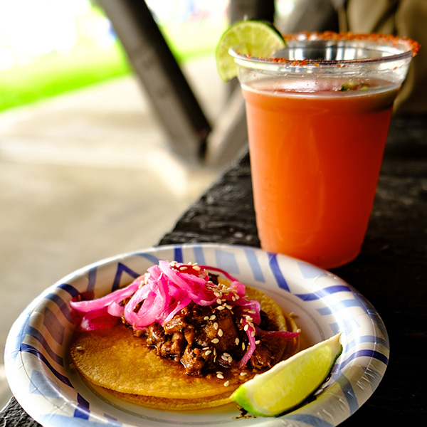 plate with tacos and orange drink with lime