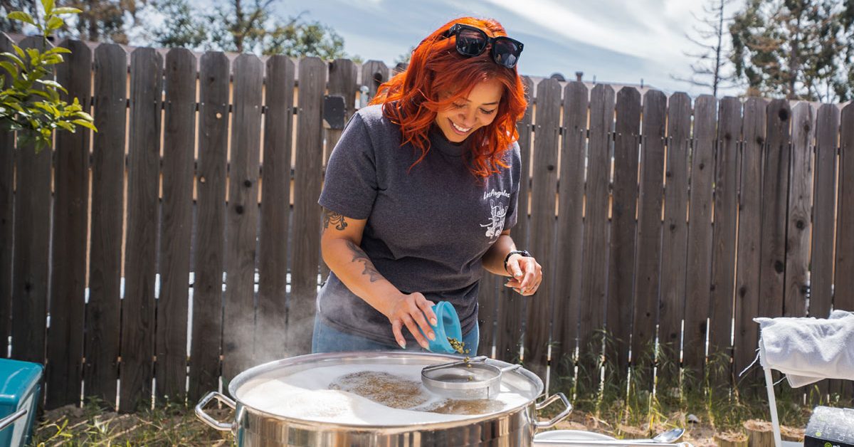 woman adding hops during homebrewing process