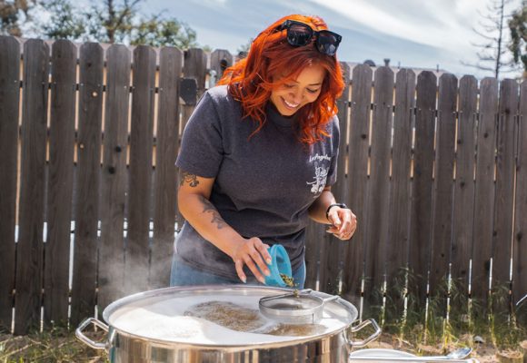 woman adding hops during homebrewing process